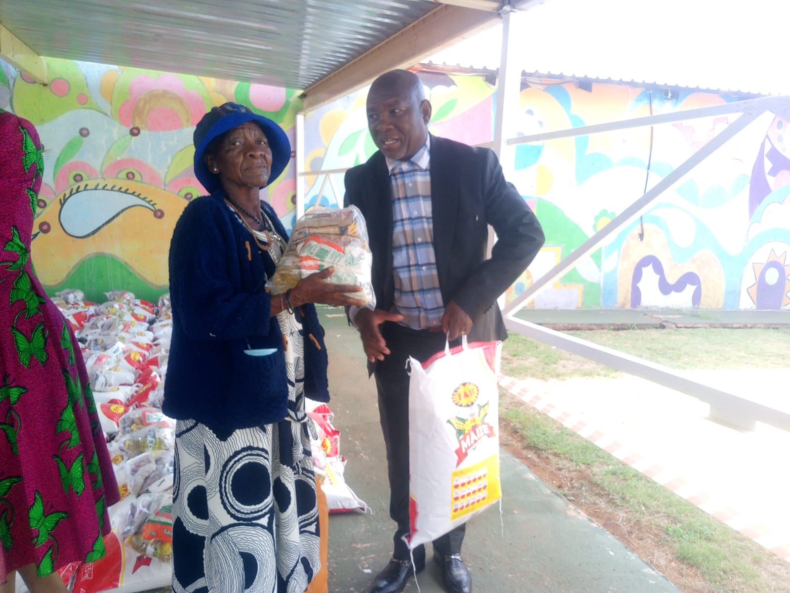 Member of Parliament Kenny Motsamai hand over food parcel to ggoo Nora Kau (81) in Rama City Tshwane