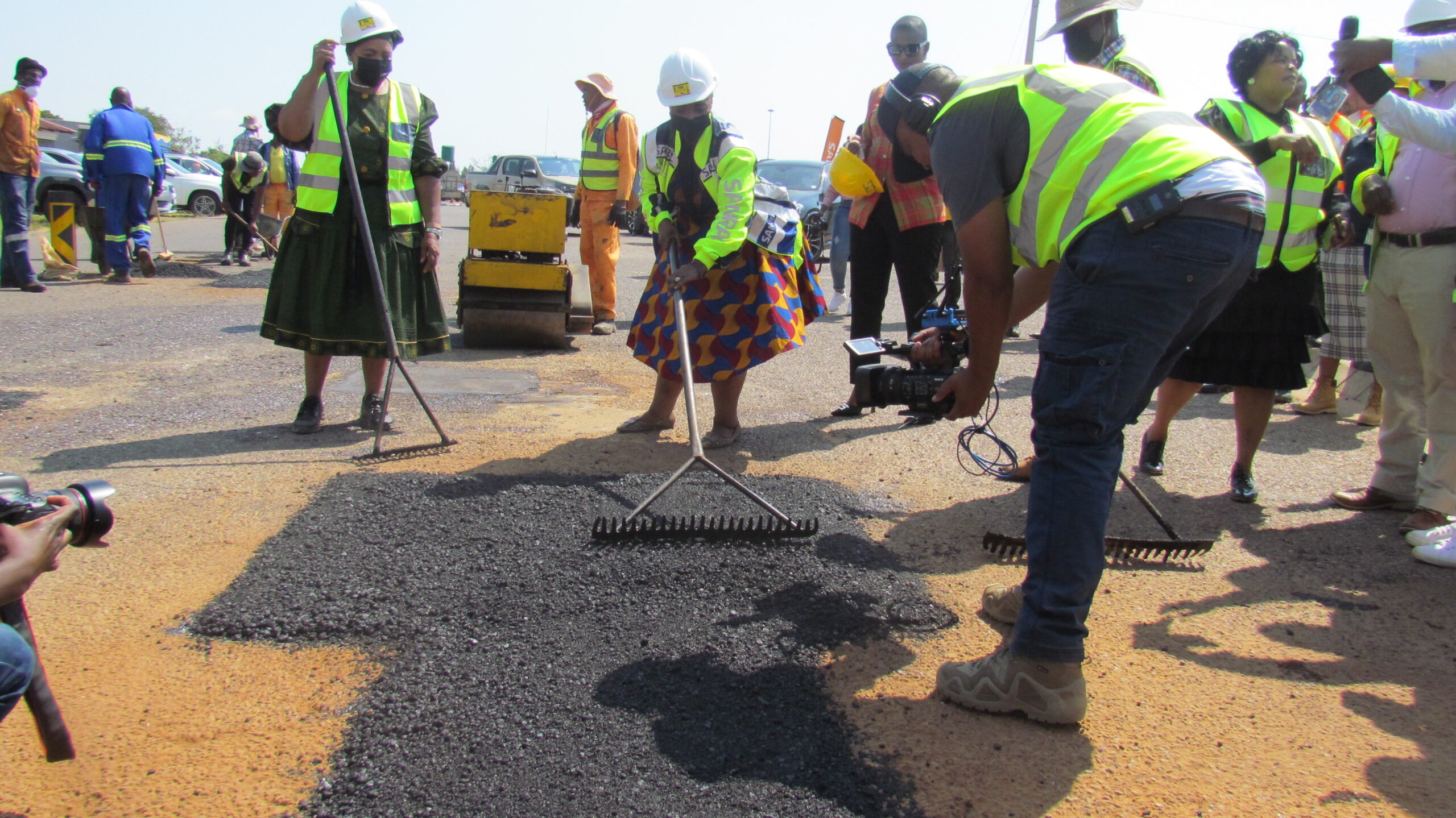Minister of Transport Sindisiwe Chikunga helped construction workers to patch the road in Moloto photo by Dimakatso Modipa