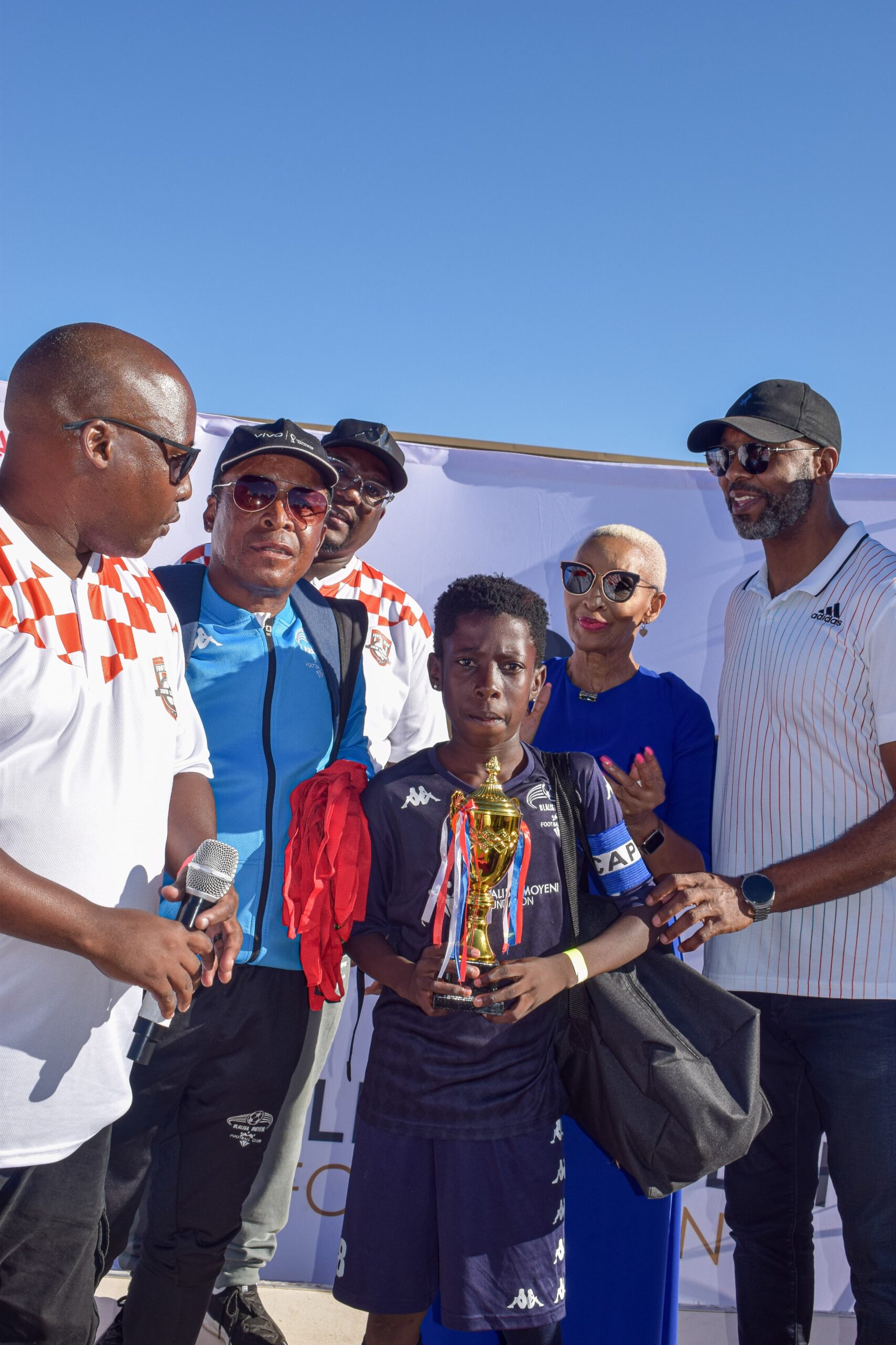 Captain of the team that won the Under 13 tournament poses for a photo with Ria Ledwaba, Lucas Radebe, coach  Ngulu and Dlalisa Foundation Spokesperson Themba Masango photo by Peter Mothiba