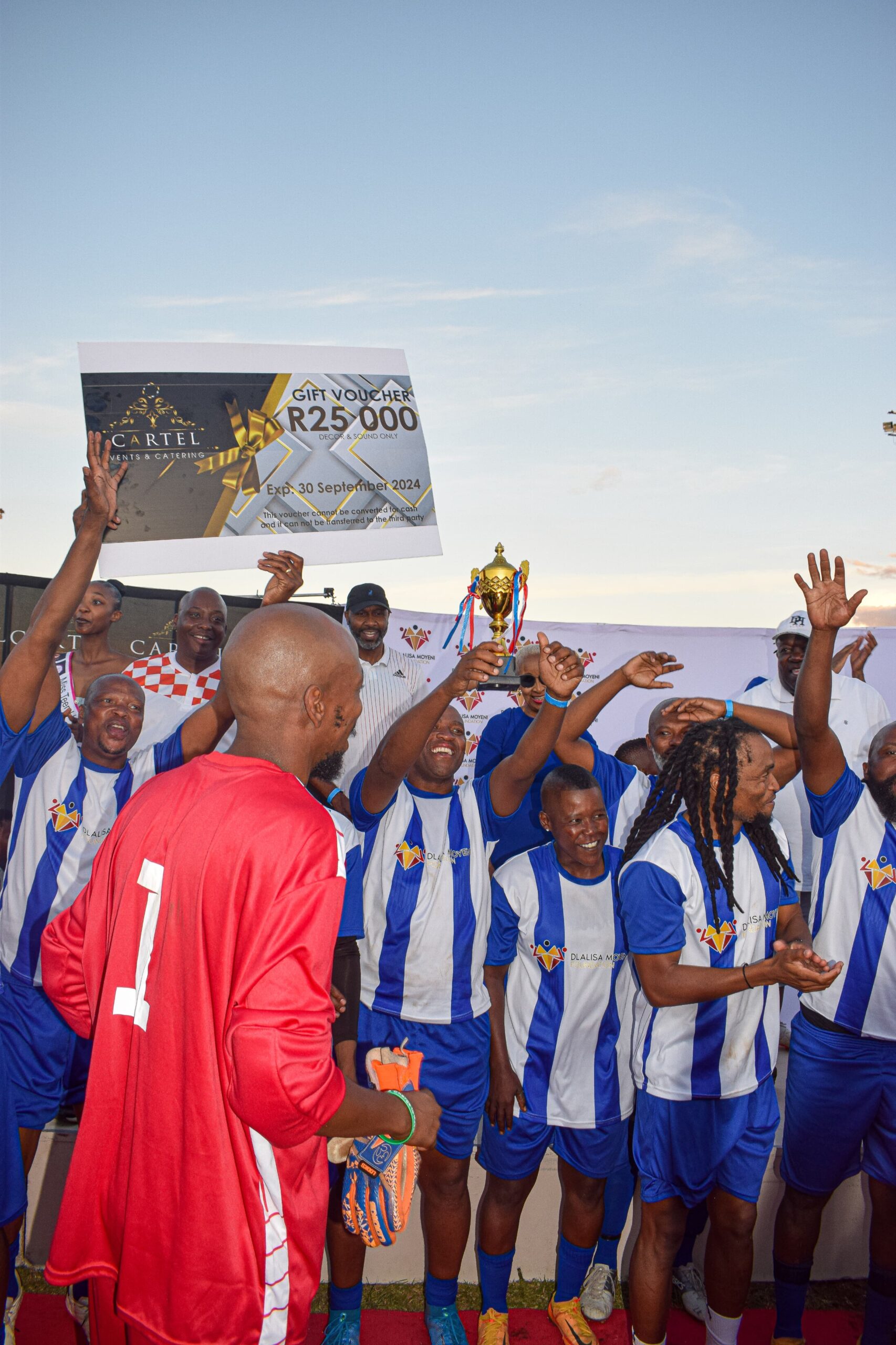 Members of the Themba Mnguni's team that won the legends' match posing with the cheque of their prize money photo by Peter Mothiba