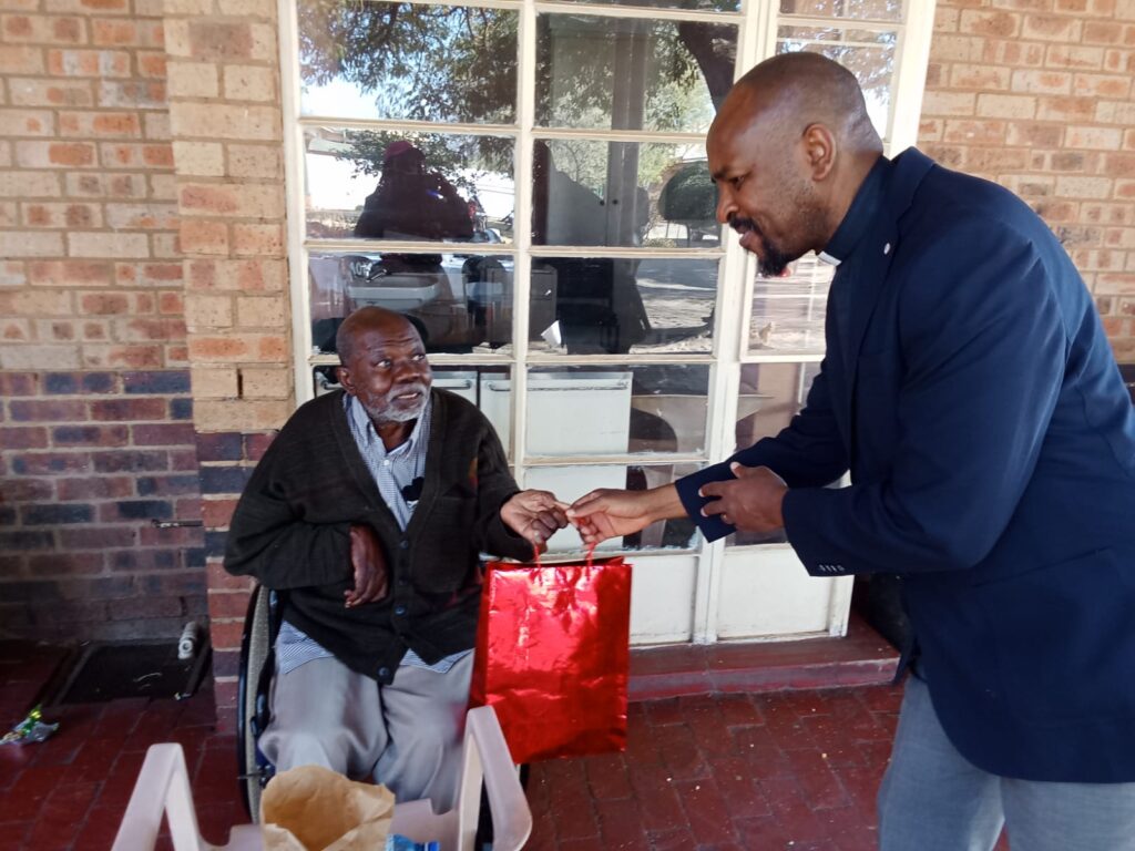 Rev Thembani JImmy Mayayise from Evangelist Presbyterian church in South Africa hands out toiletry to elderly at Mamelodi Old age home 