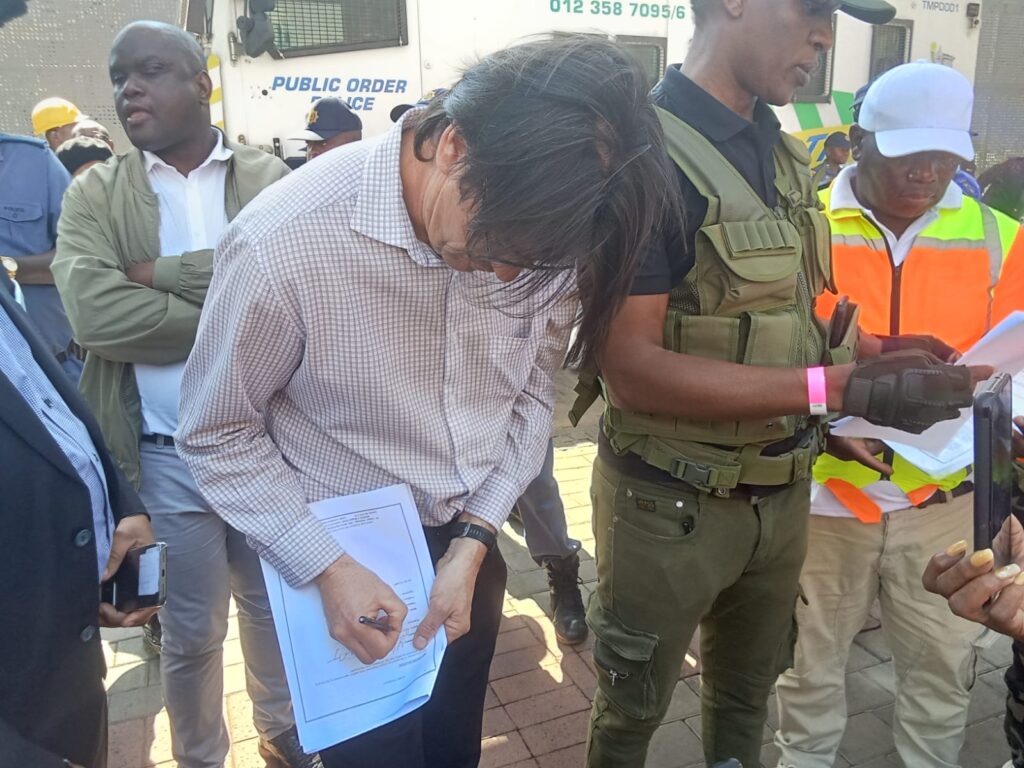 An official from city of Tshwane Willlie Venter sign a memorandum 