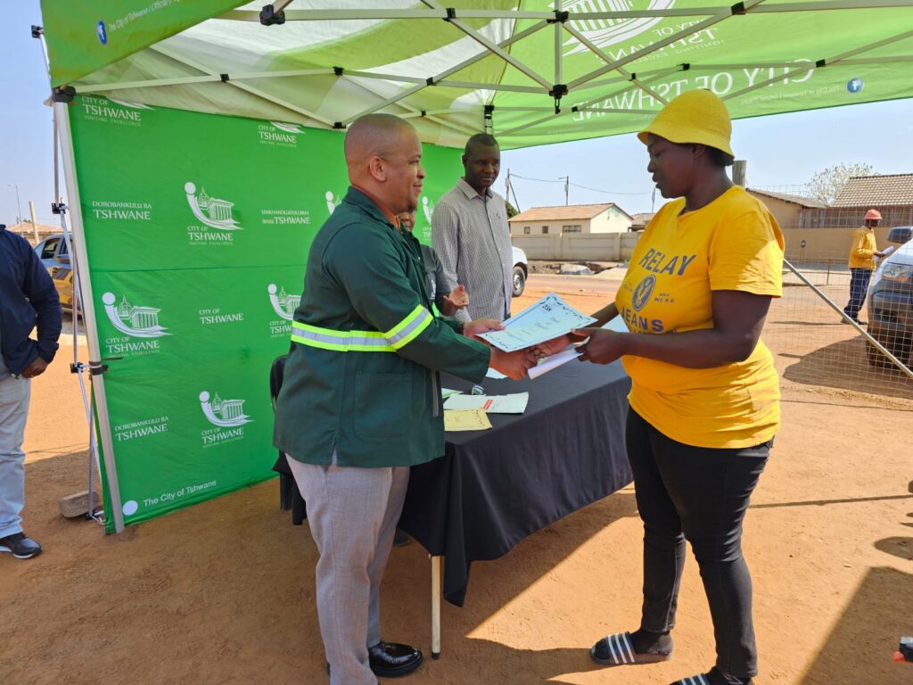 City of Tshwane MMC for Human Settlement Ofentse Madzebetela handing over tittle deed to residents of Soshanguve