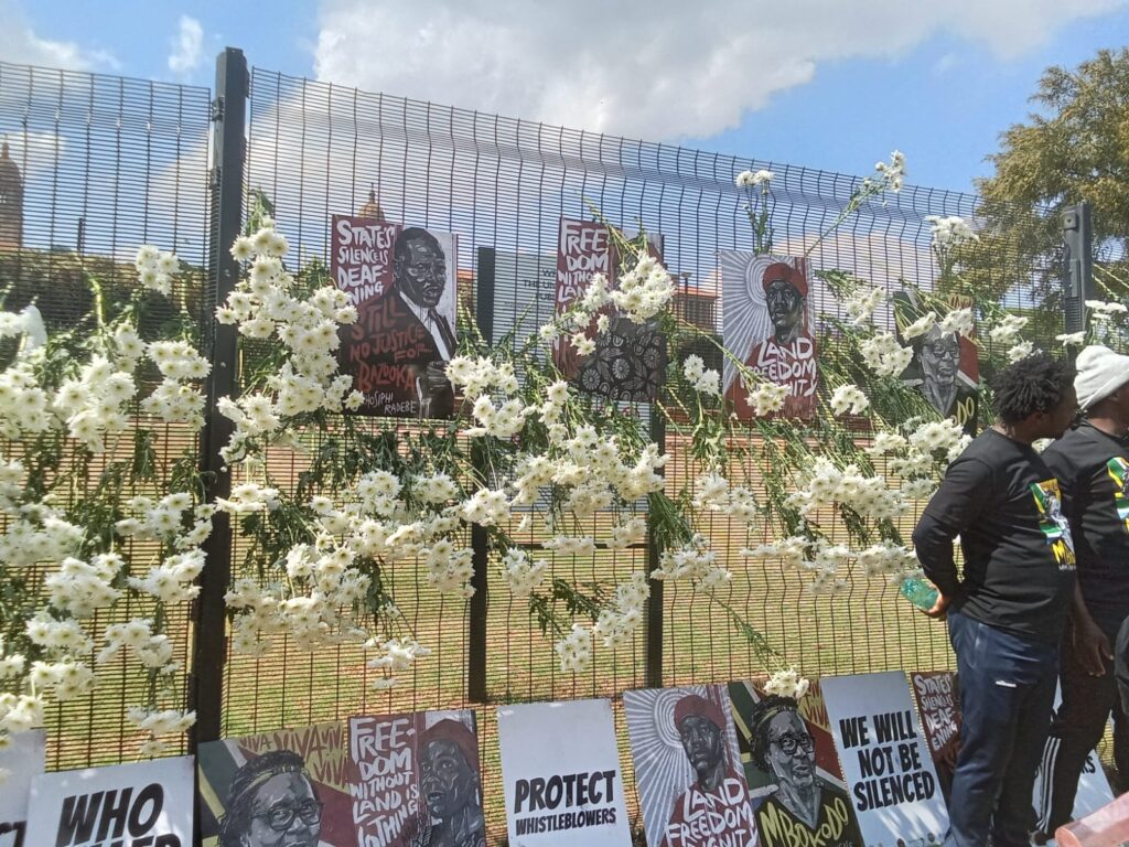 Photos of the defenders who were killed, place at Union Buildings gate and flowers