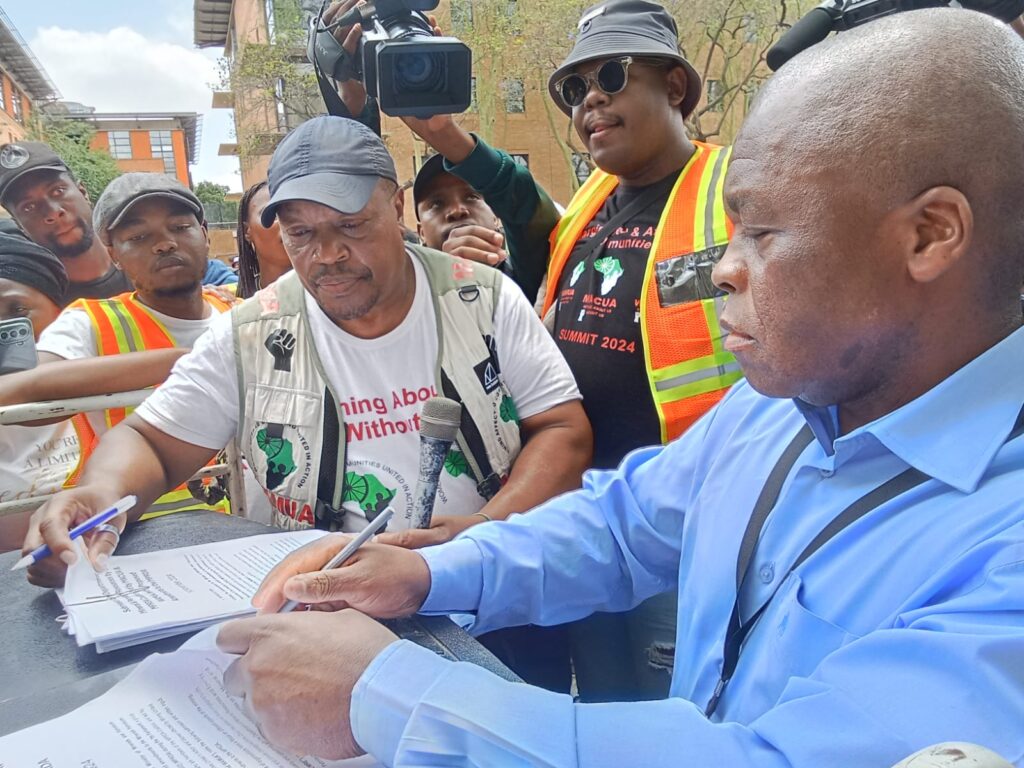 Director at DMRE Edward Gugulethu sign a memorandum