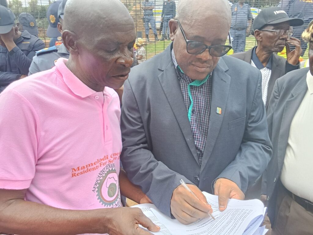 Phillemon Mahlangu from the office of the presidency sign a memorandum