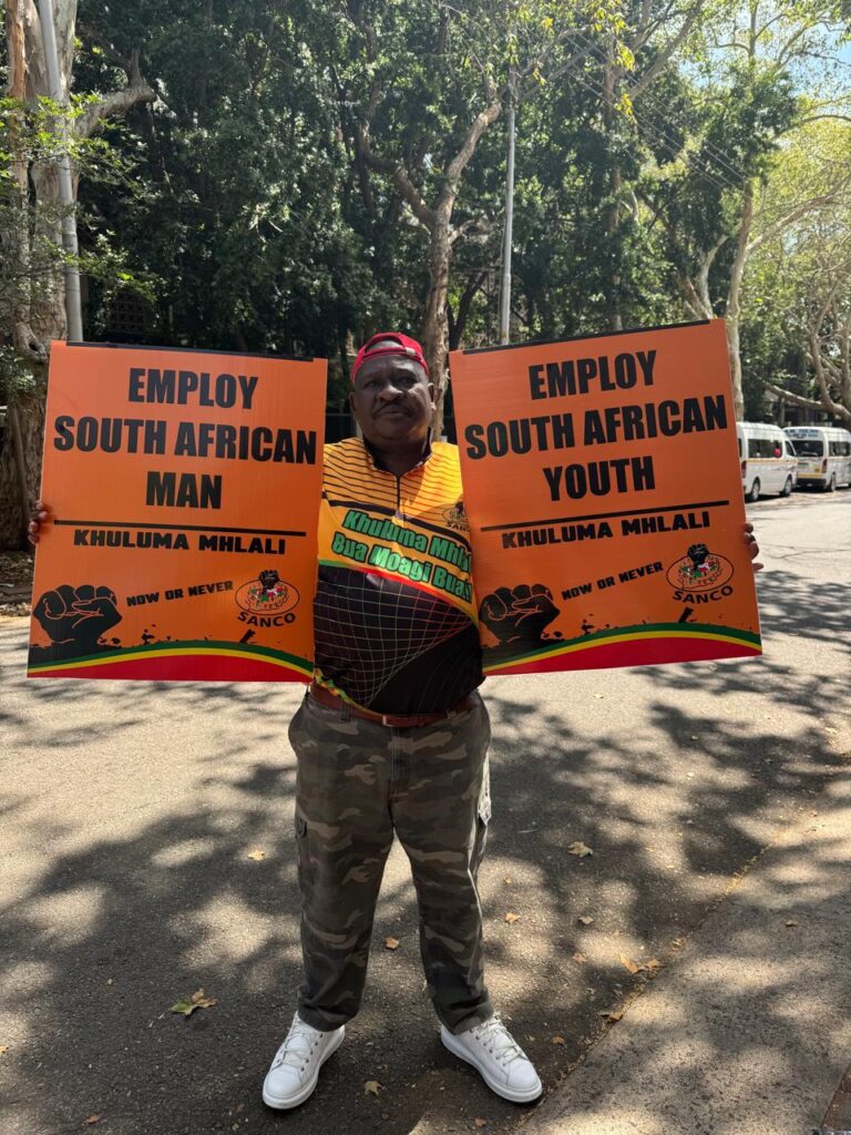 SANCO Gauteng Provincial Chairperson Abram Mashishi holding placards in protest at the Union Buildings on Thursday 12 December