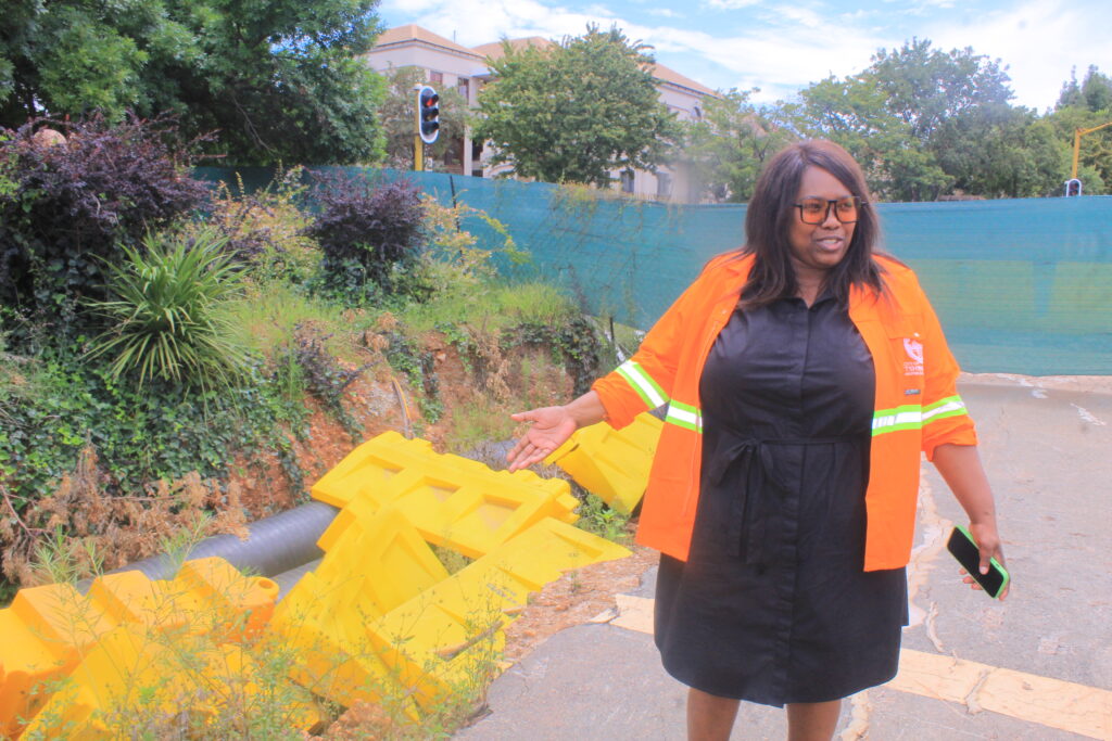 MMC for Corporate and Shared Services Kholofelo Morodi standing next to a sink hole in Centurion photo by Dimakatso Modipa