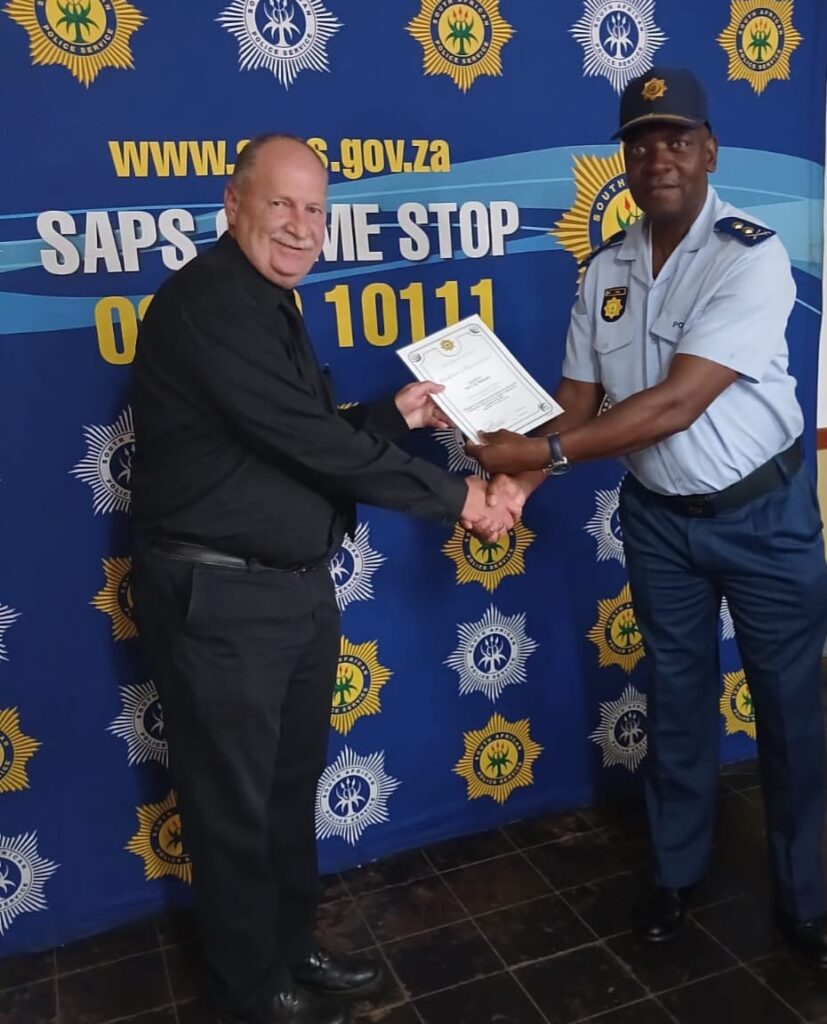 Warrant-Officer R Booysen receiving his certificate from the District Commissioner of Tshwane, Major-General Samuel Thine