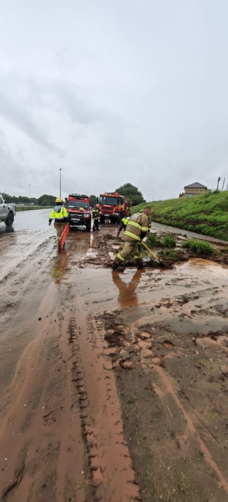 Emergency Services officers clearing the road after it was hit by floods