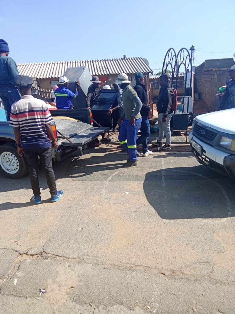 Community members helping the Nkosi family  load their belongings onto a vehicle after they were evicted