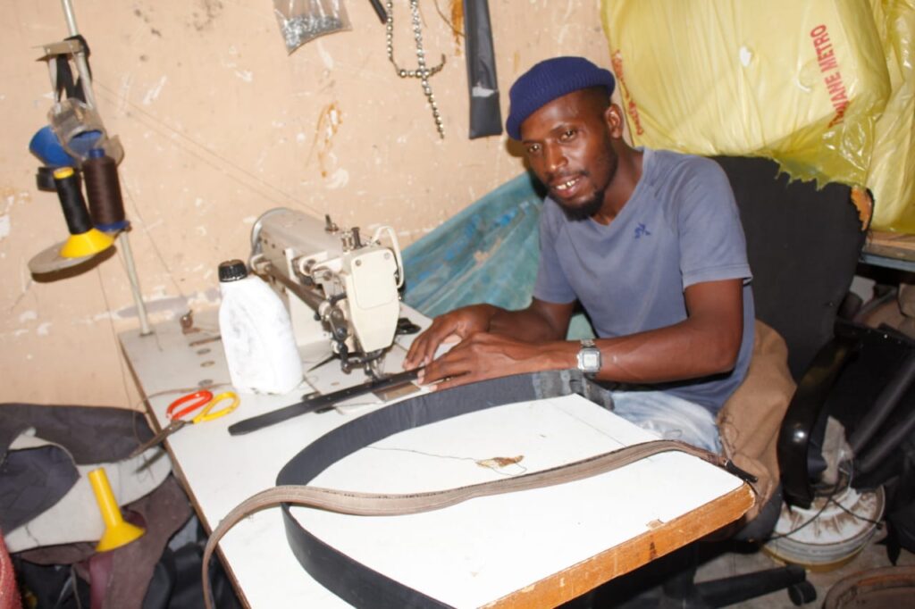 Raphelani Mathegu of IMD Upholstery knits belts at his machine.