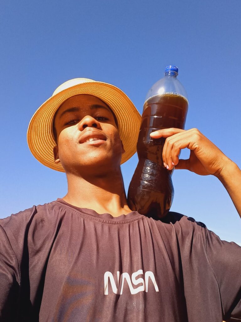 Kwena Ngwepe with a two-litre bottle of self-made diesel on his shoulder