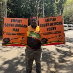 SANCO Gauteng Provincial Chairperson Abram Mashishi holding placards in protest at the Union Buildings on Thursday 12 December